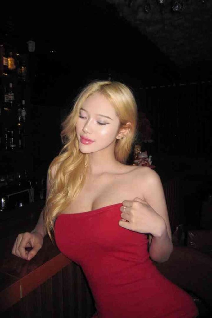 Blonde woman in red dress at a bar. Erdene, alluring Mongolian escort in KL.