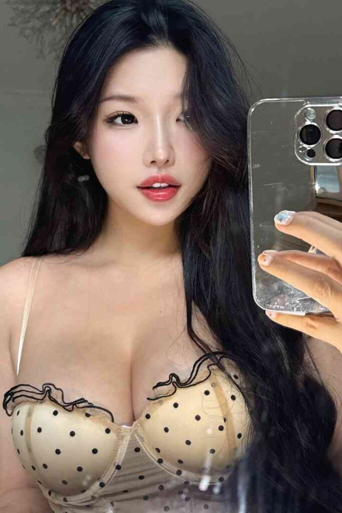 Nomin, exotic Mongolian beauty in polka dot bra taking a selfie.