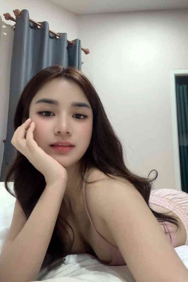 Yanis, a stunning 22-year-old Malay woman, poses in bed.